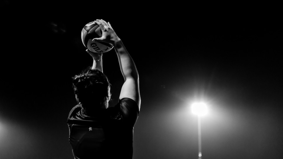 a black and white photo of a student holding up a ball
